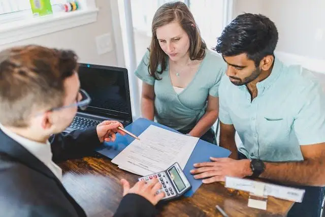 Expert realtor in a real-estate office giving financial guidance to a family seeking a new home or property.